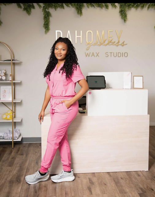 Jessica Sade, founder of Dahomey Goddess Wax Studio, standing at the studio front desk